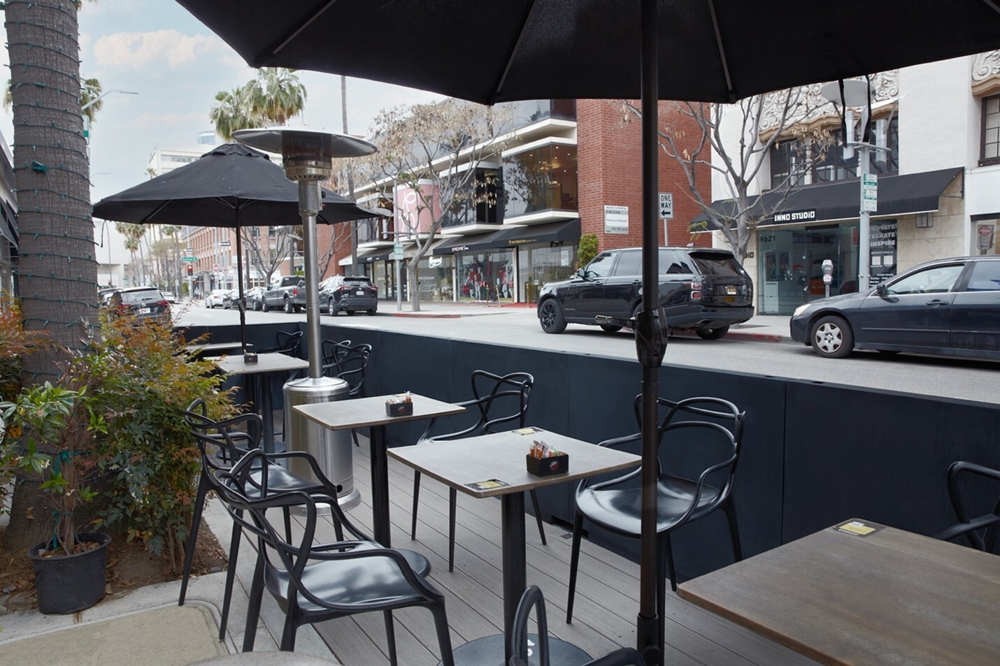 Tables and chairs under umbrellas in parklet