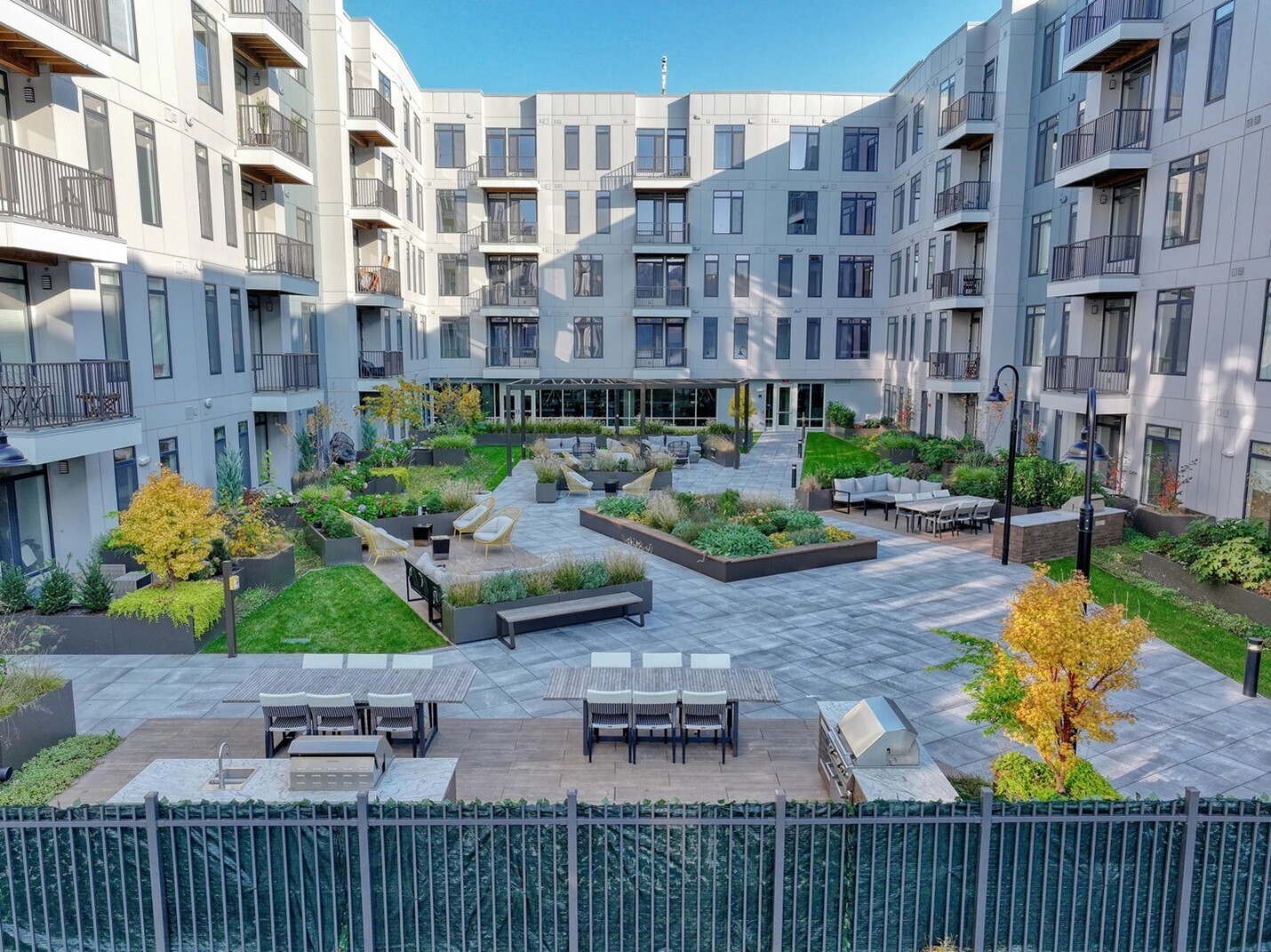 Planters with different textures and colors highlight richly colored plantings in landscaping